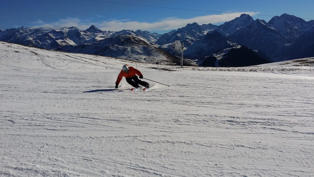 Skier skiing on the snow with mountains in the background